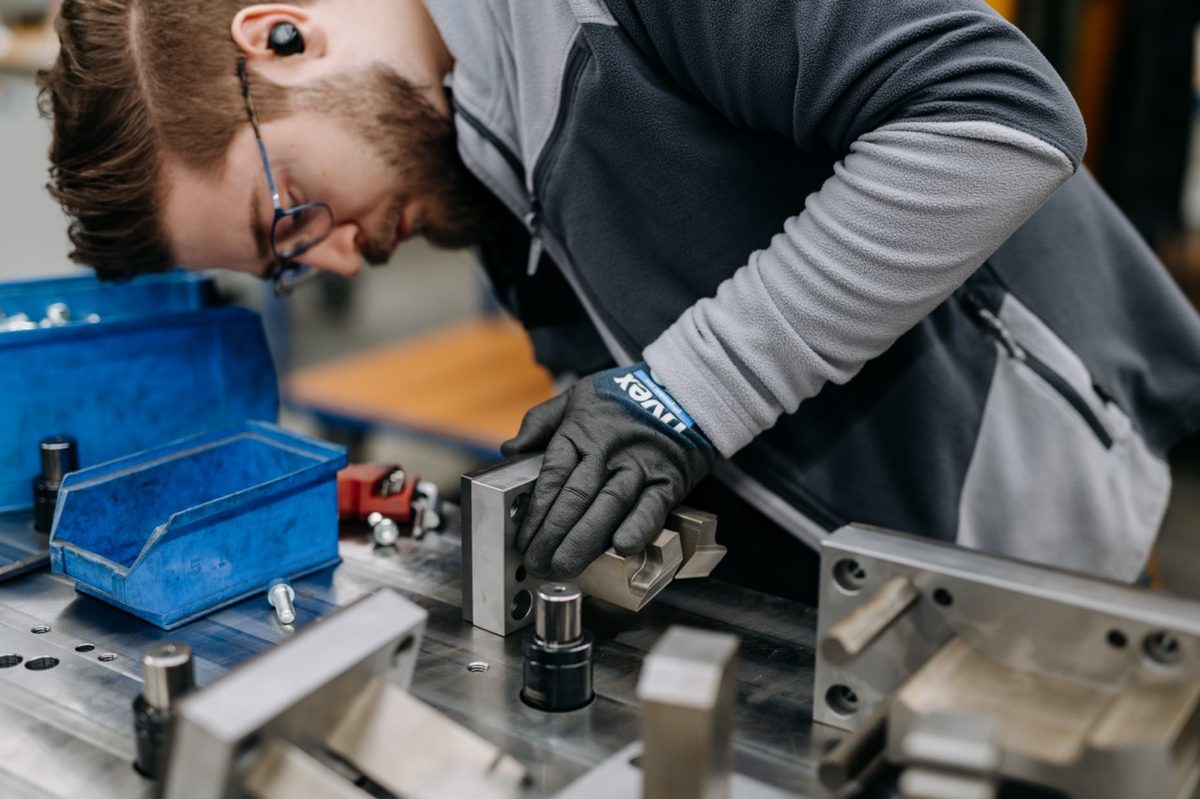Auszubildender arbeitet konzentriert an einem Stanzwerkzeug