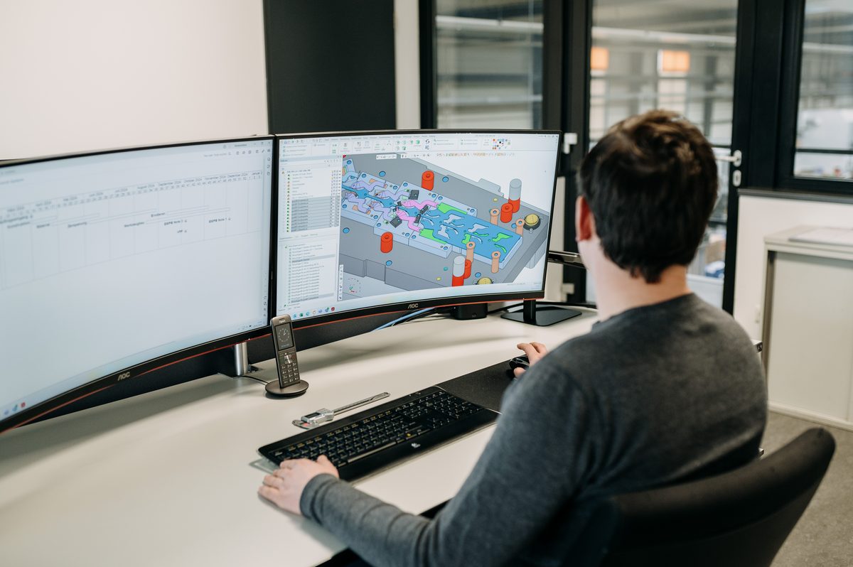 Konstrukteur am CAD-Arbeitsplatz mit dem 3D-Modell eines Stanzwerkzeugs