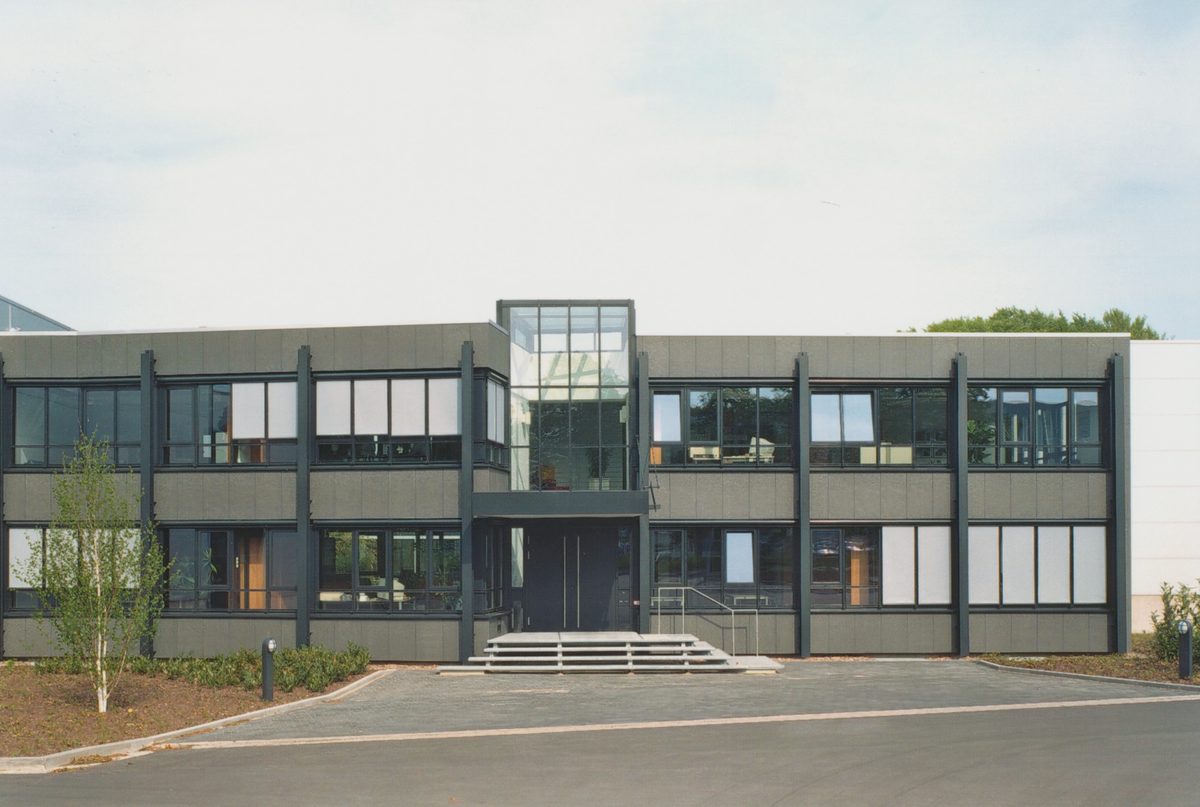 Zweigeschossiges Verwaltungsgebäude mit Glasfassade und Vorplatz
