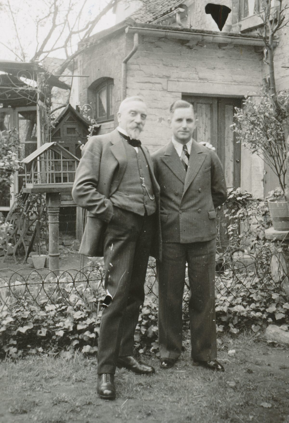 Zwei Männer im Anzug in einem Garten, historische Aufnahme