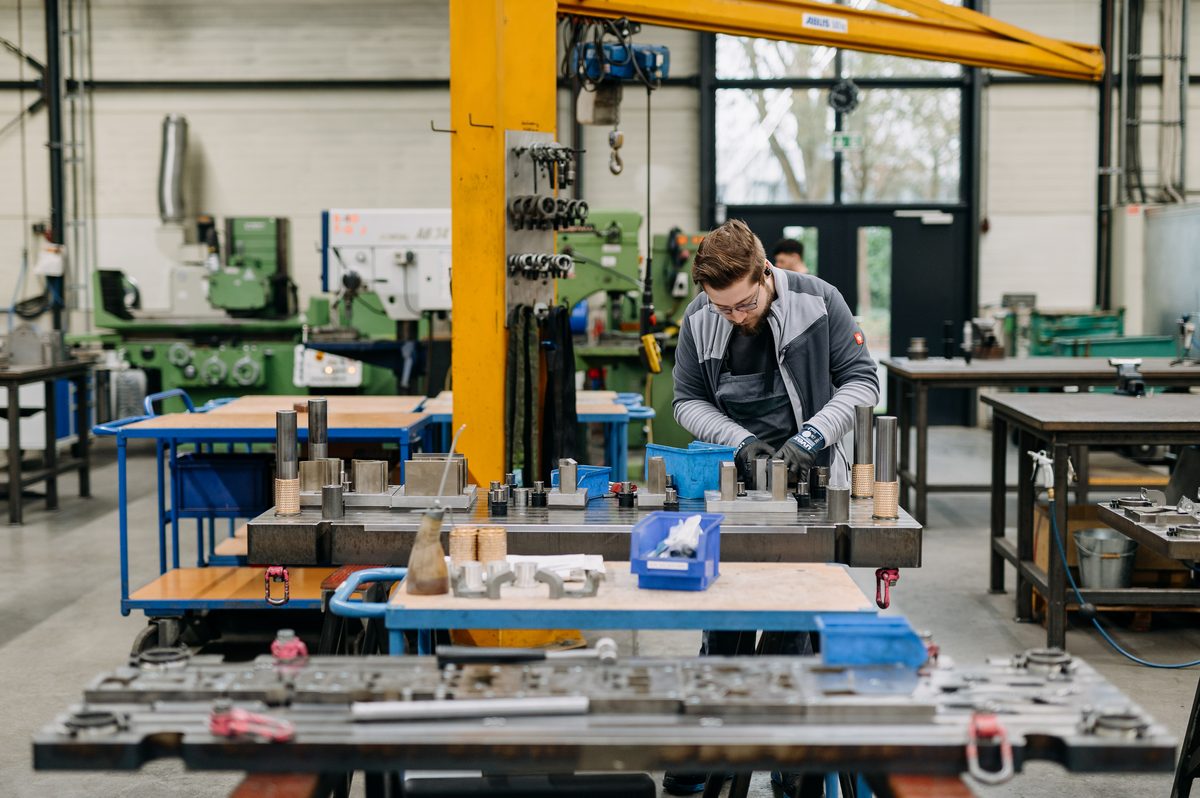Werkzeugmechaniker montiert ein Stanzwerkzeug auf der Werkbank